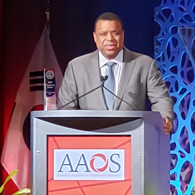 Photo of Dr. Michael Parks at the podium addressing the AAOS Annual Meeting.