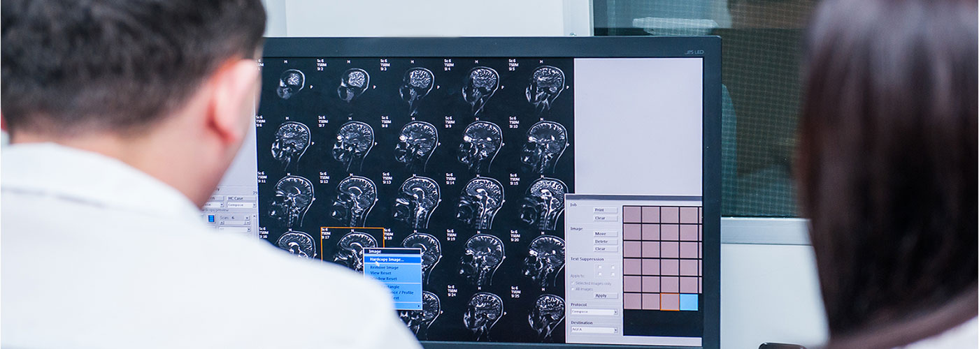 Banner image of a physician reviewing image scans.