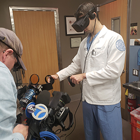 Photo of Dr. Yuri Pompeu operating the VR training tool
