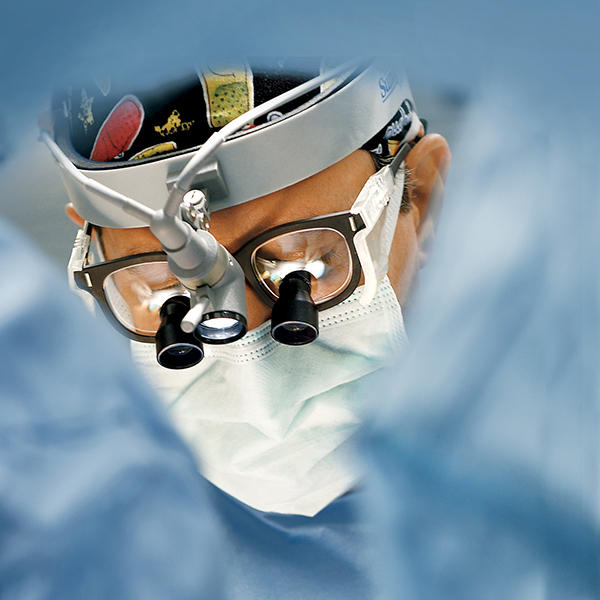 Image - surgeon using magnifying lenses