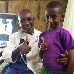 A FOCOS doctor with a pediatric patient giving a thumbs up sign