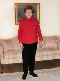 Photo of Joan Campbell standing in her living room.