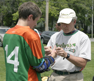 Photo of John Cavanaugh examining a lacrosse player