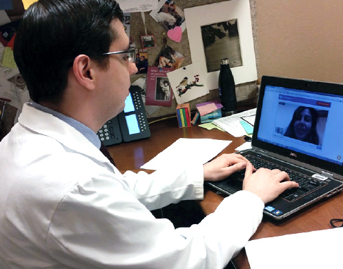 Photo of a physician at a laptop, using the telemedicine platform.