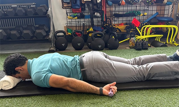 Prone exercise start position lying face down with arms at the side