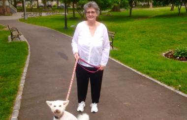Senior woman walking her dog in the park
