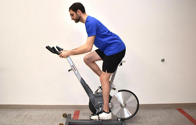 man on exercise bike demonstrating body positioning