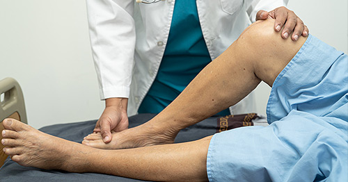 A medical professional examining a patient's knee.
