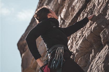 photo of man rock climbing