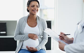 pregnant woman talking to reproductive health specialist
