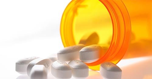 Pills spilling out of a bottle.