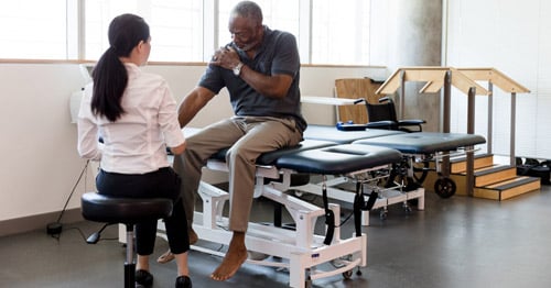 Middle aged man getting occupational therapy for upper extremity.