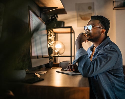 photo of a man working on his computer at night