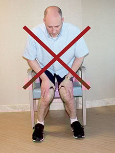 Photo showing the incorrect way to rise from a chair.