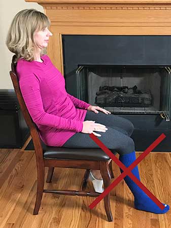 Photo of a woman sitting incorrectly with her right foot on the floor and not elevated as instructed
