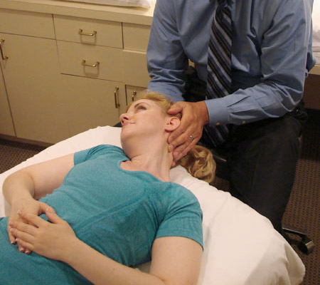 Photo of neck stretch while the patient is lying on their back.