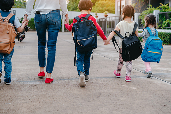 photo of children walking with backpacks