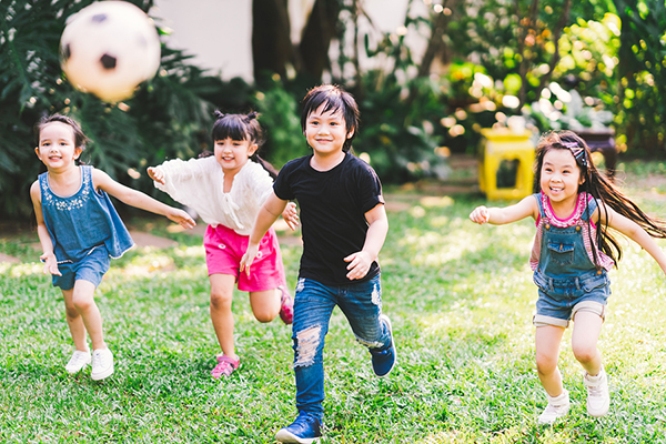 Kids playing with soccer ball outside