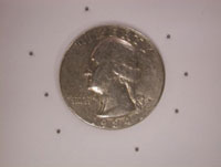 Image showing the relative size of the implanted tantalum beads to a US quarter