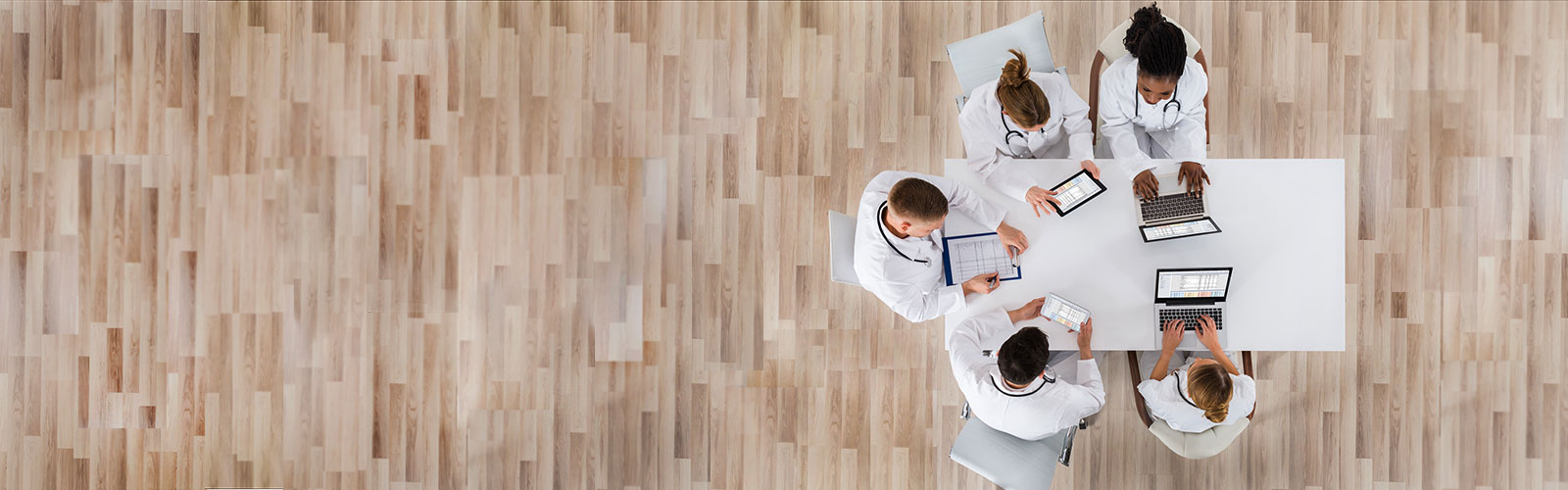 Banner image - A group of physicians sitting together at a table collaborating.