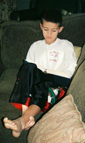 Bobby sitting on a couch reading.