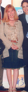 Photo of Colleen standing and smiling.