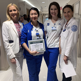 Photo of Lidia Tskhay, RN, BSN, ONC, holding her award alongside SVP and Chief Nursing officer Jennifer O'Neill and two other Nursing staff members.