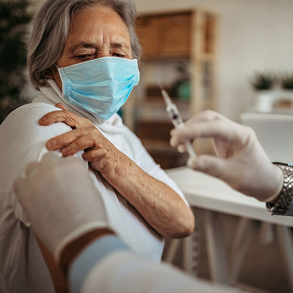Older woman receiving the COVID-19 vaccine.