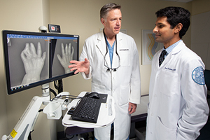 Photo of Drs. Daluiski and Trehan examining an X-ray of the hand.