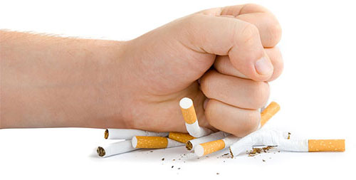 Photo of a fist smashing cigarettes.