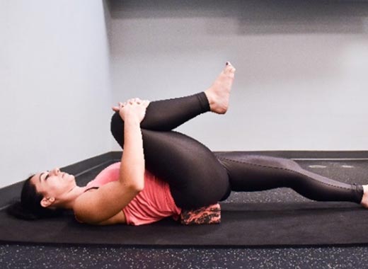 photo of cara demonstrating Knee-to-chest stretch