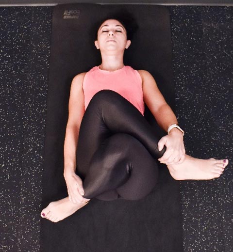 photo of cara demonstrating Reclined cow-face stretch