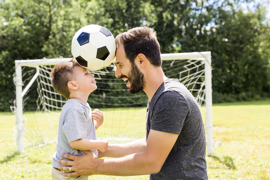 child with father on soccer field