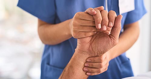 A clinican holding a patient's hand.