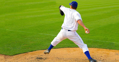 A baseball pitcher in the early cocking position.