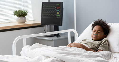 A child asleep in a hospital bed.