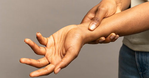 Close up of a person holding their wrist.