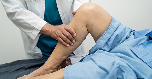 A doctor examining a patient's leg.