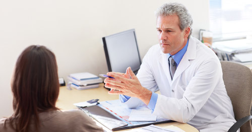 A doctor speaking with a patient in the office.
