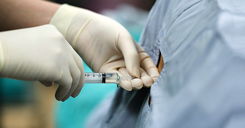 A clinician administering an epidural injection.