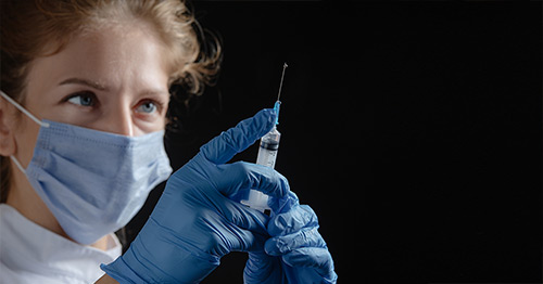 A clinician holding a syringe.