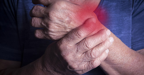 An older person with joint pain in the wrist.