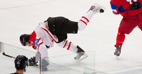 An ice hockey player falling down.