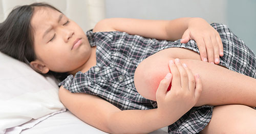 A child holding her knee in pain