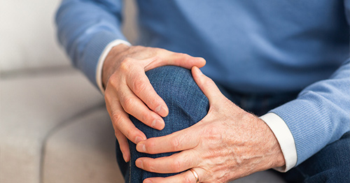 Man holding knee in pain.