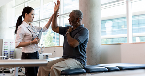 A man getting physical therapy for the shoulder.