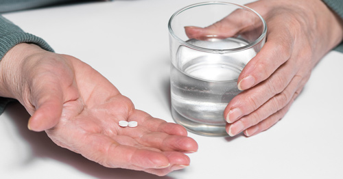 A hand holding pills.
