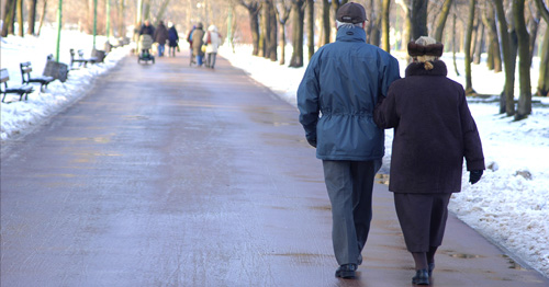 An older couple walking in a park.