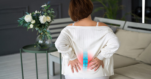 A woman with back pain in the lumbar spine area.