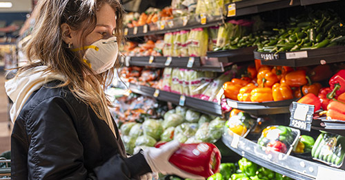 Woman selecting vegetables at the grocery store.